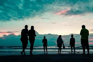 group of people on beach at sunset