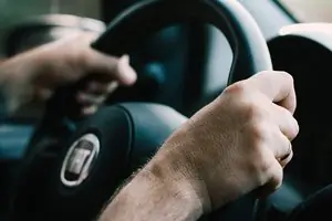 driver confident they have car hire excess cover with hands on steering wheel